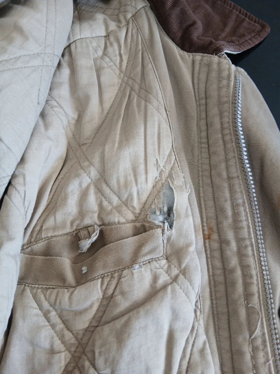 Campera color beige con cuello de pana marrón. Posee cierre y botones al frente. Tiene bolsillos con cierre y solapa.