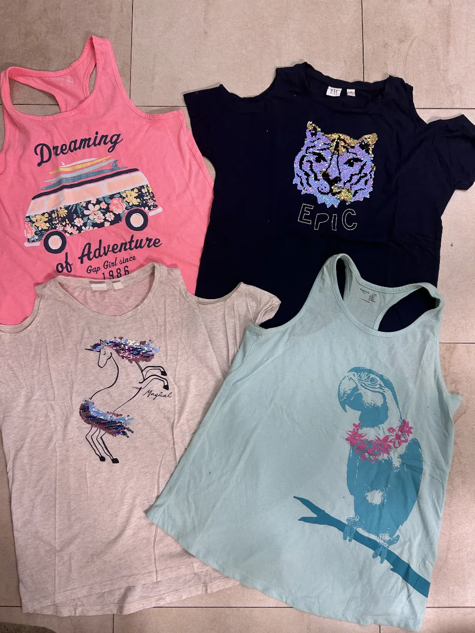 Musculosa rosa de niña con estampado de una combi con tablas de surf y la frase 'Dreaming of Adventure'. Ideal para un look casual y aventurero.