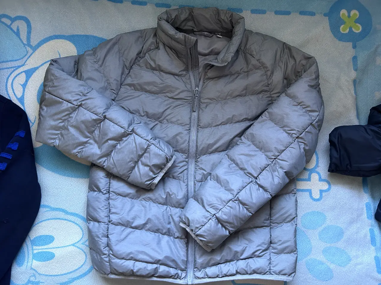 Campera de pluma gris de la marca Uniqlo, ideal para el frío. Talle 11-12.