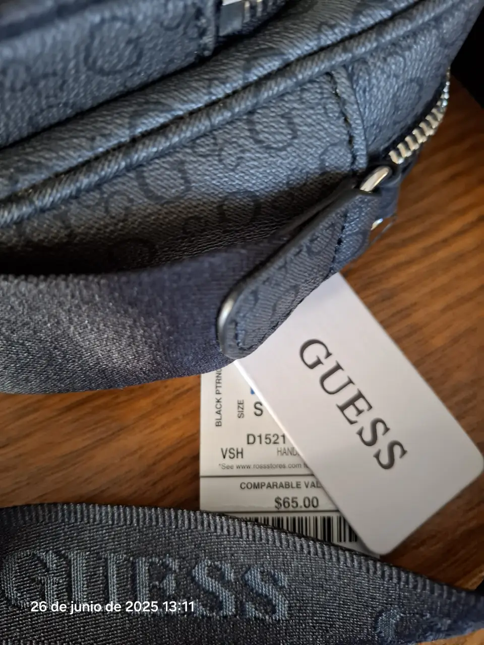 Bandolera Guess negra con estampado del logo de la marca. Cuenta con dos bolsillos frontales y correa ajustable. Ideal para llevar tus esenciales con estilo.