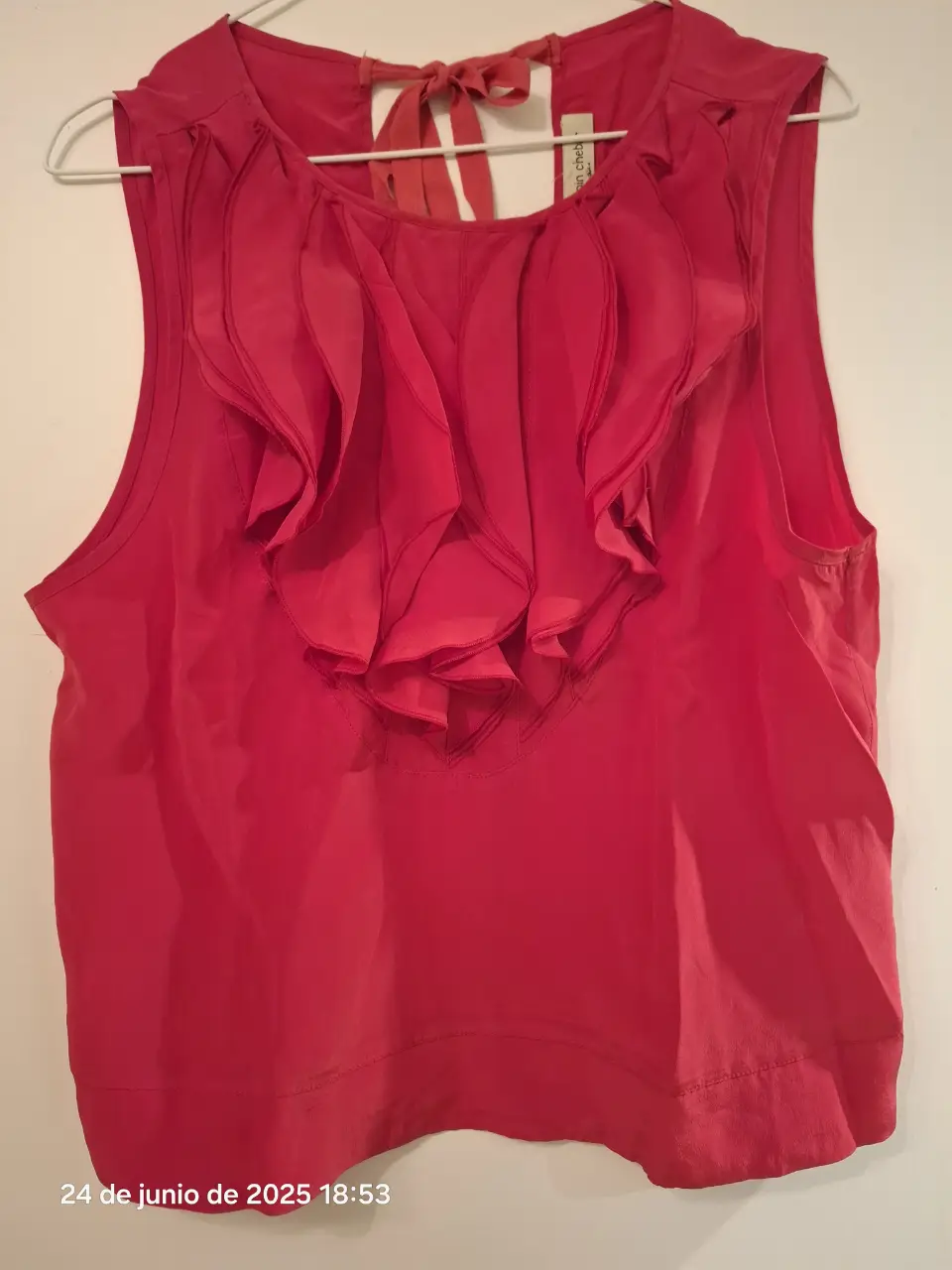 Blusa roja sin mangas con detalle de volantes en el cuello. Ideal para un look elegante y femenino.