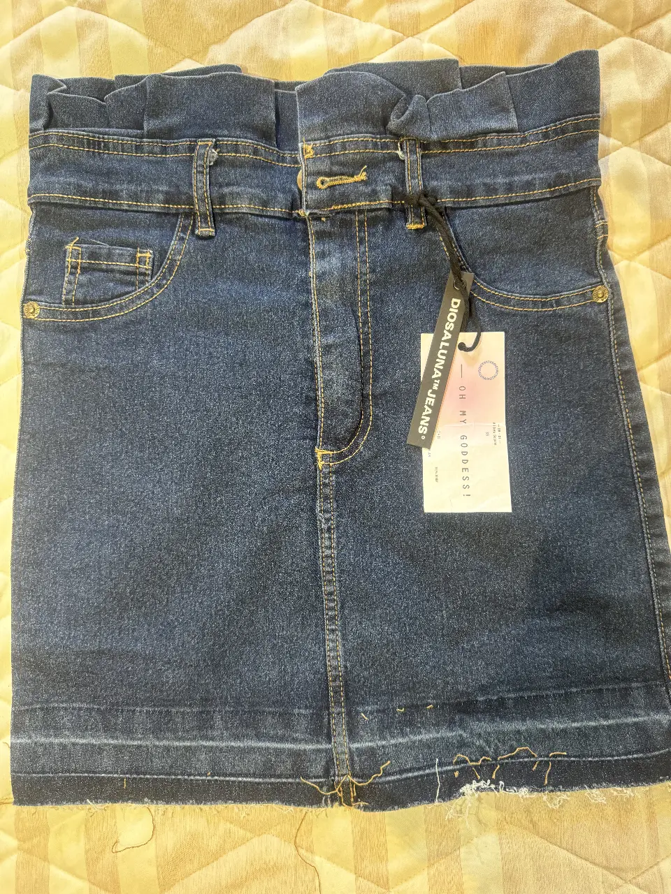 Minifalda de jean azul oscuro con cintura fruncida y detalle de etiqueta. Ideal para un look casual y moderno. 40cm de largo y 35cm de cintura. Elastizada. Lo oscuro de abajo al costado es la sombra del celular cuando saqué la foto.