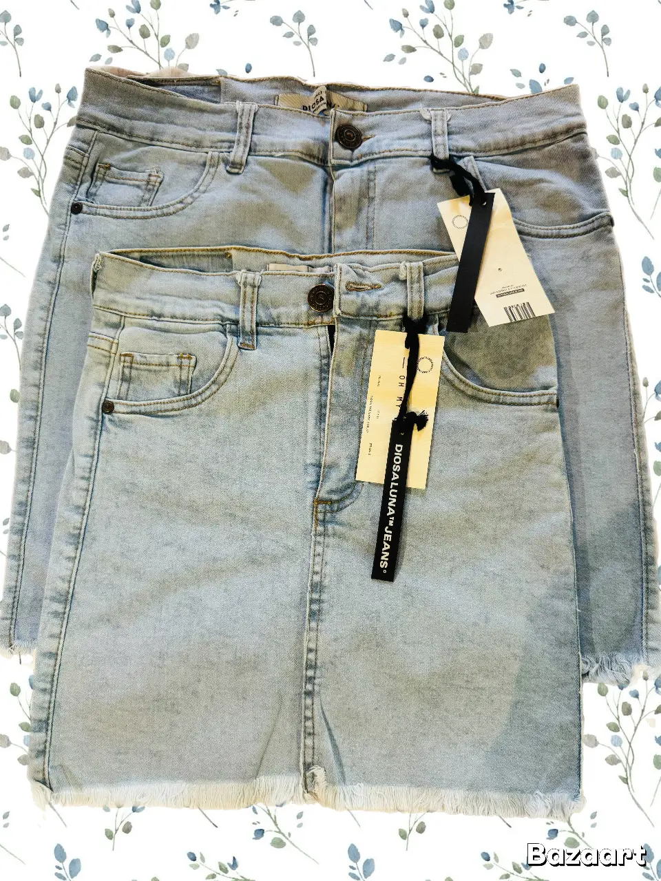 Pollera de jean celeste claro, tiro alto, con detalles de desgaste y flecos en el borde inferior. Ideal para un look casual y moderno. 36cm de largo y 31cm de cintura. Elastizada. Lo oscuro de la abajo es la sombra del celular.