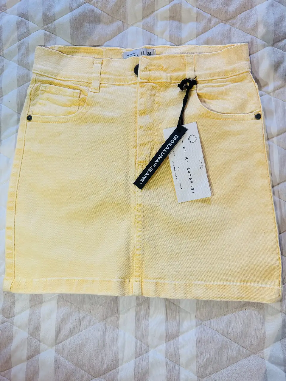 Minifalda de jean amarilla, ideal para un look casual y fresco. Confeccionada en jean de alta calidad, esta falda presenta un diseño clásico con bolsillos y un corte que favorece la figura. Perfecta para combinar con tus tops favoritos y crear outfits versátiles. 36cm de largo y 33cm de cintura.