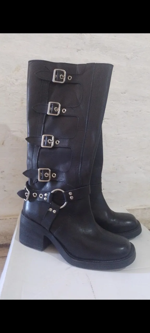 Botas de cuero negras caña alta,  con múltiples hebillas y detalles metálicos. Taco grueso y suela robusta. Ideales para un look rocker o alternativo.