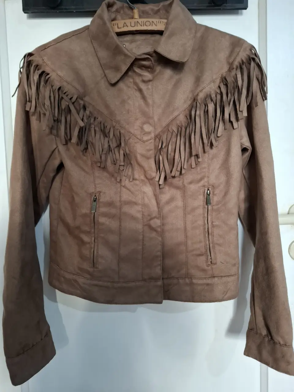 Campera de gamuza marrón con flecos en el frente y espalda. Estilo boho y vintage, ideal para un look casual y con onda.