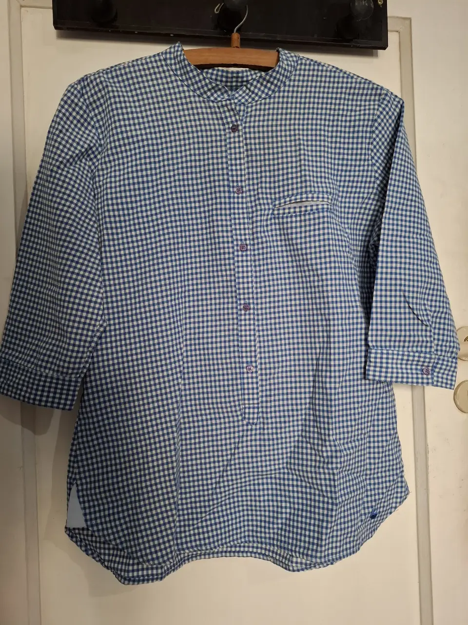 Camisa de mujer a cuadros azul y blanco, con mangas 3/4 y cuello mao. Ideal para un look casual y fresco.