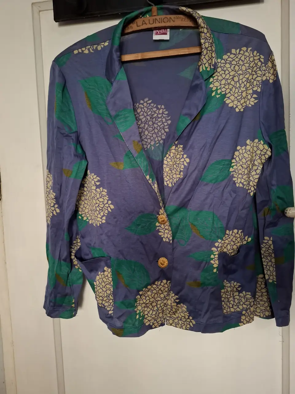 Camisa de mujer vintage con estampado floral en tonos azul y verde, con botones dorados. Ideal para un look elegante y con estilo.