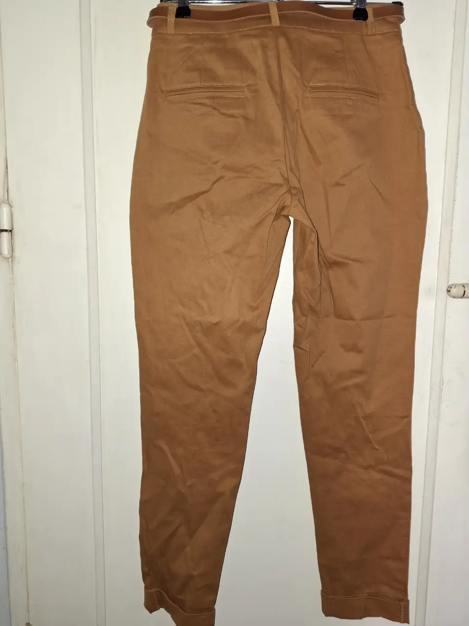 Pantalón chino de mujer, color marrón, corte recto y tiro medio. Ideal para un look casual o de trabajo. Confeccionado en tela resistente y cómoda. Puede ceder hasta un talle 38.