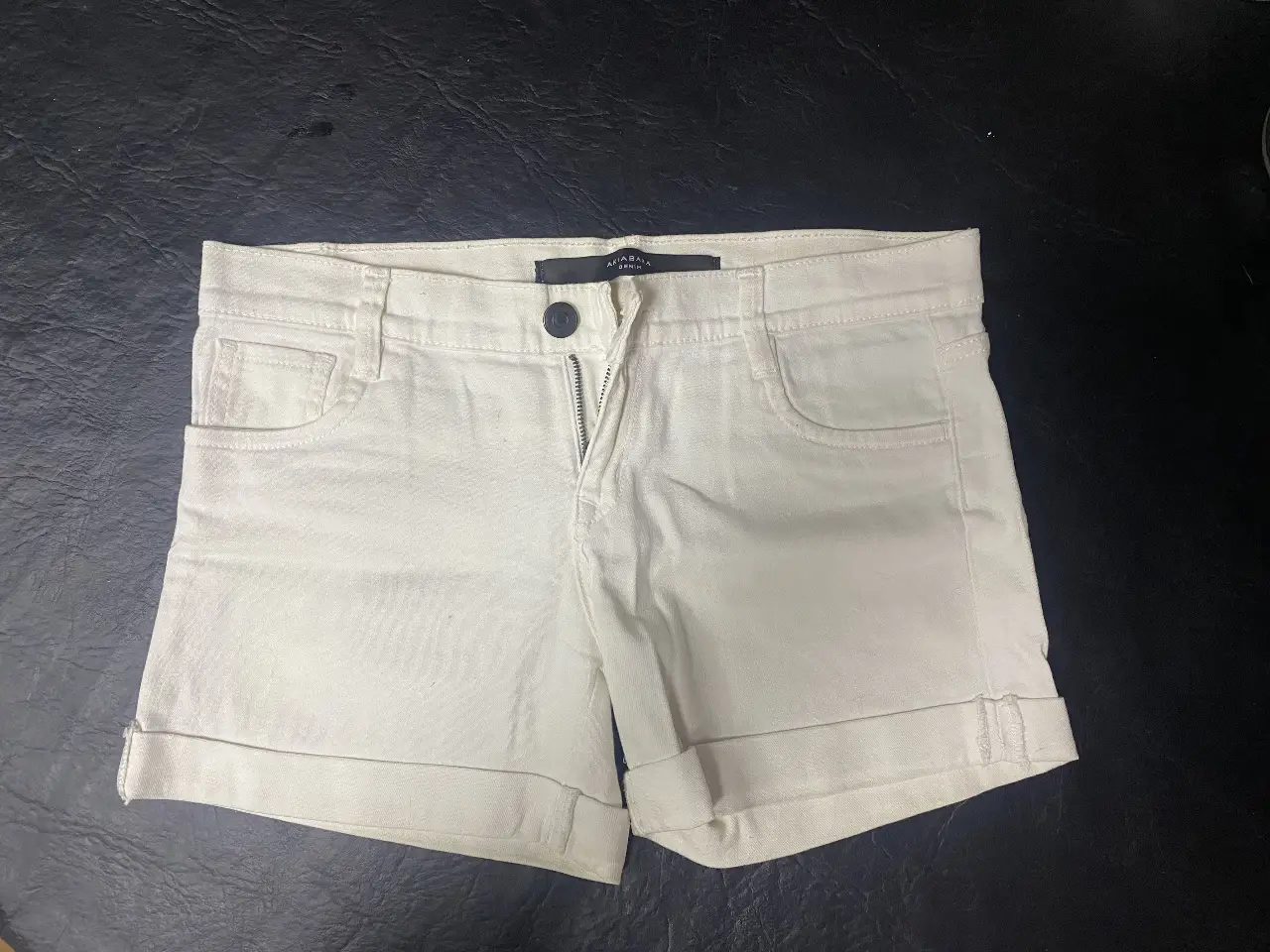 Short de jean blanco de la marca Akia Bara Denim, tiro medio, con cierre y botón. Ideal para un look casual y fresco.