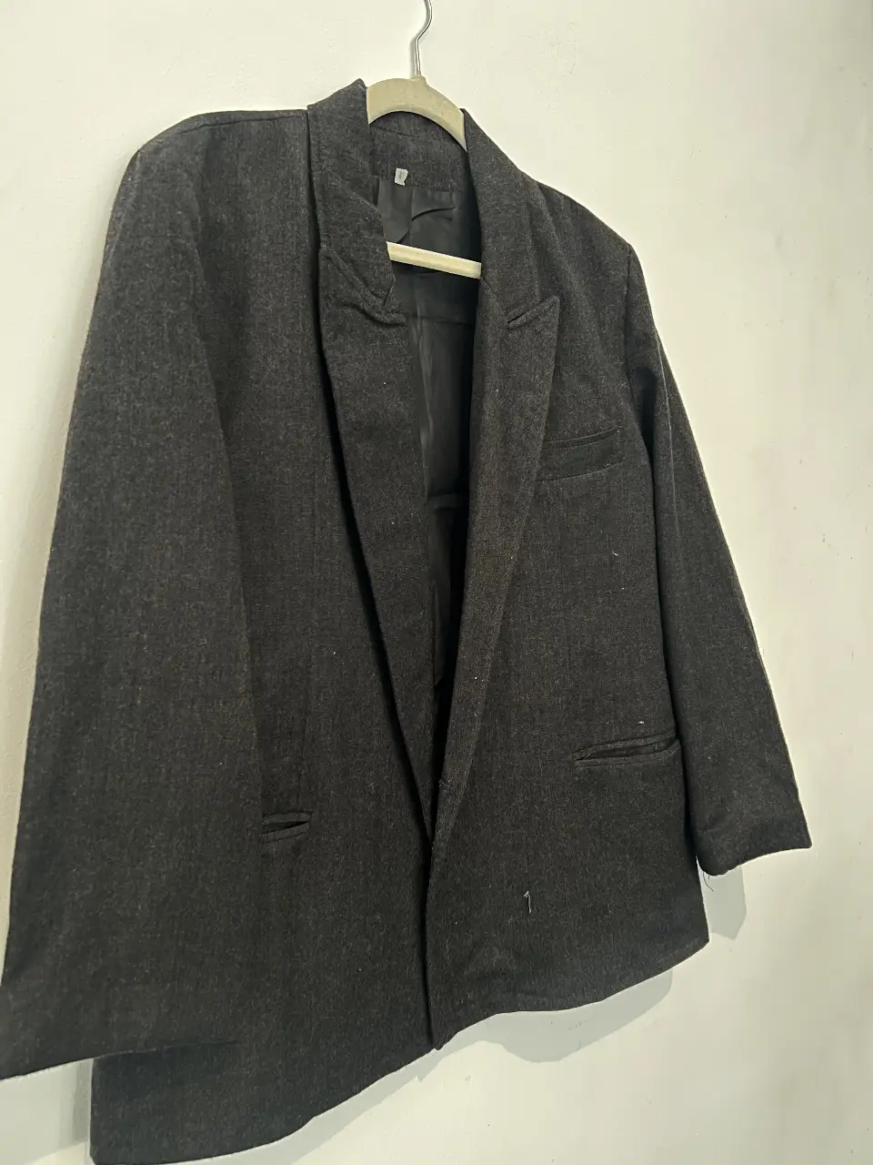 Blazer de hombre, color gris oscuro, con dos bolsillos frontales y uno en el pecho. Ideal para un look formal o casual.