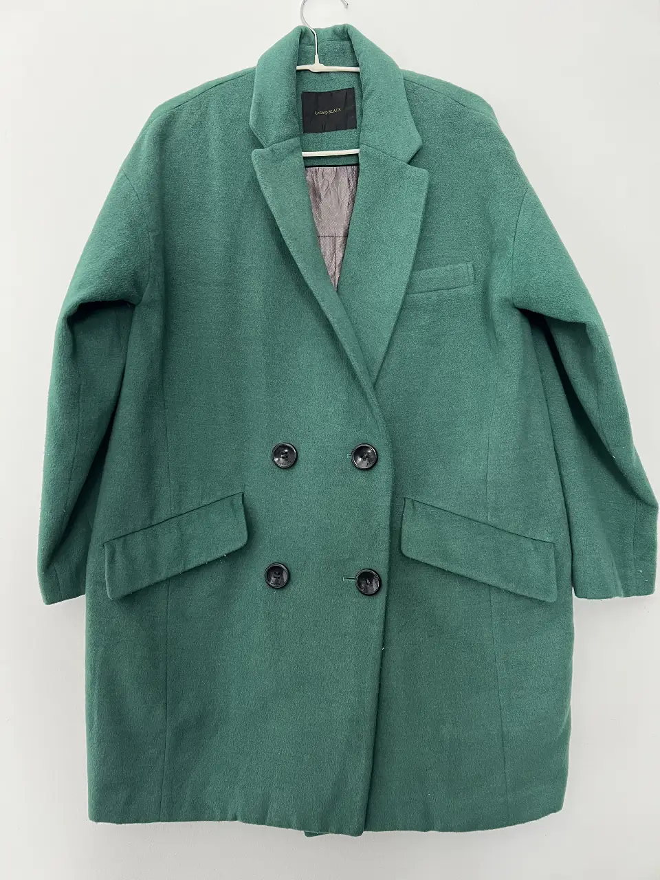 Sobretodo de paño verde, con corte clásico y doble botonadura. Ideal para un look elegante y abrigado en invierno.