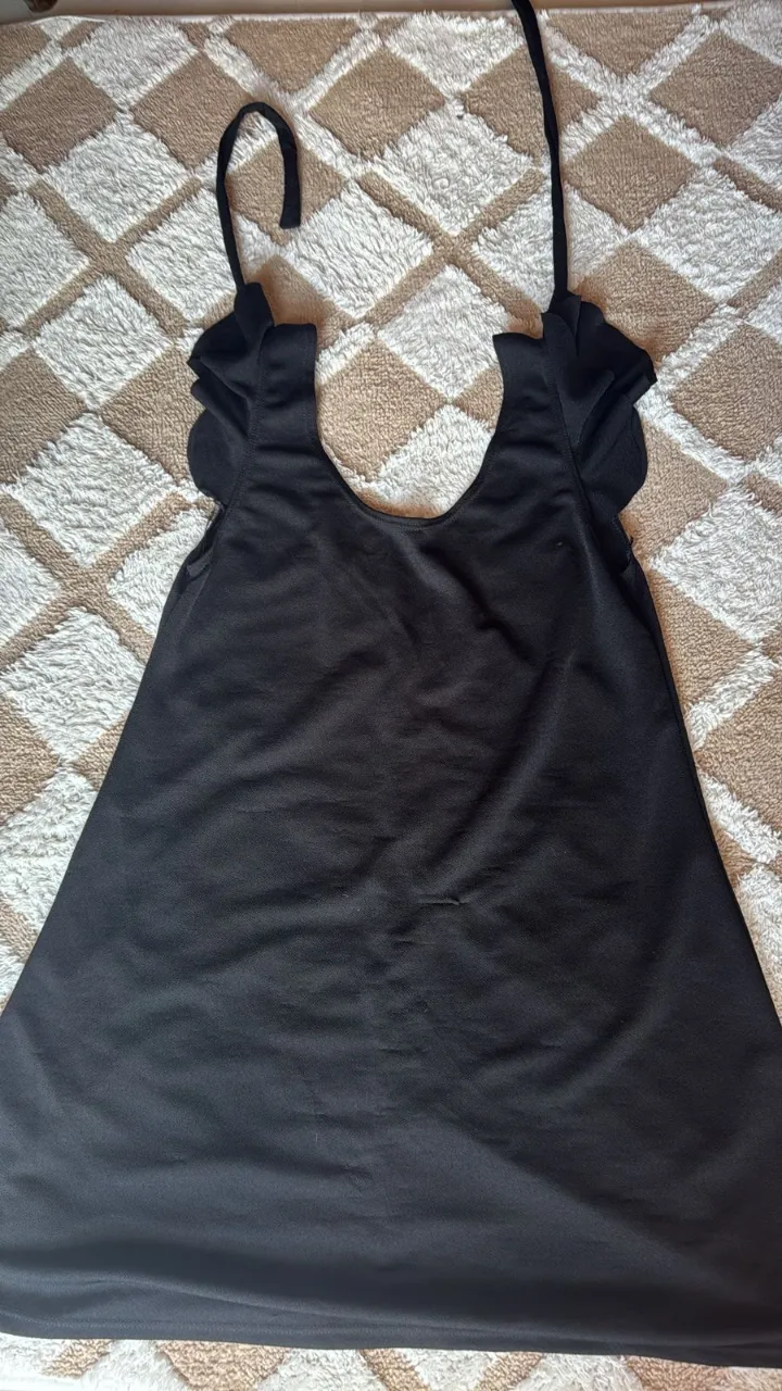 Vestido negro con tiras finas y mangas cortas con volados.