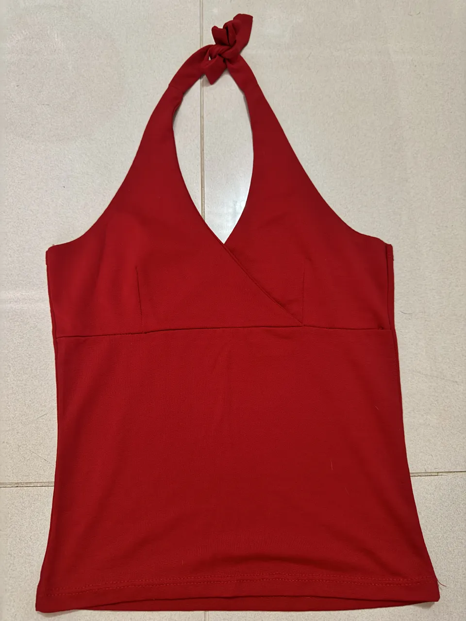 Top rojo escote halter con lazo en cuello. Posee detalle cruzado en el busto.
