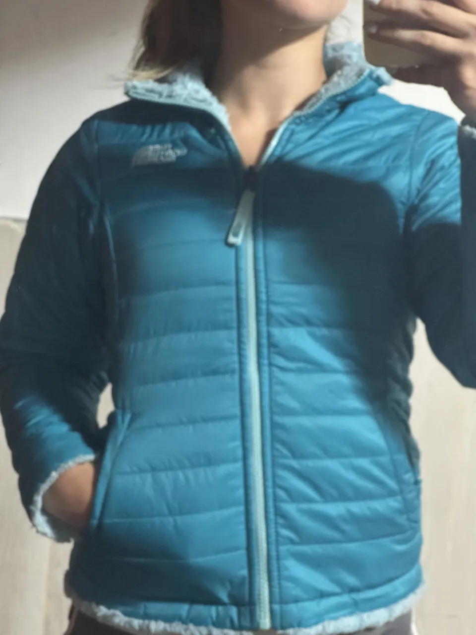 Campera reversible con capucha. Por un lado es acolchada de color azul. Por el otro lado es de peluche de color celeste.