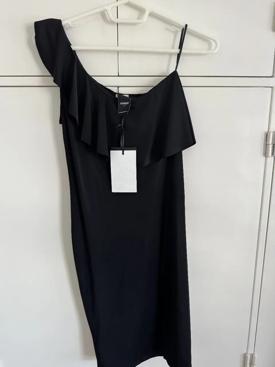 Vestido negro mini con un solo hombro y volado en la parte superior. Ideal para una fiesta o salida nocturna.