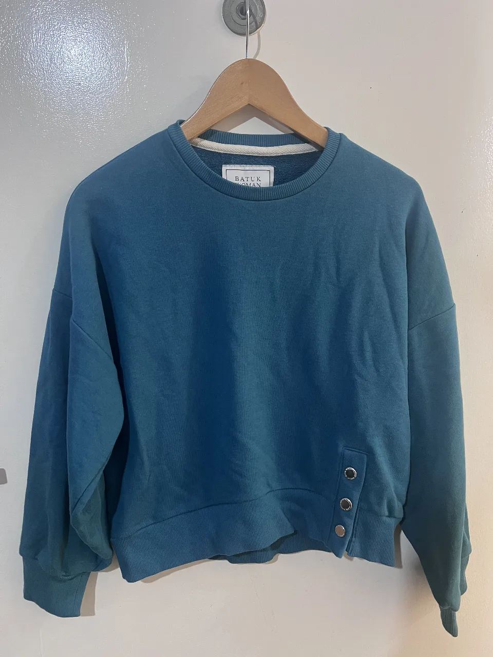 Buzo de cuello redondo para mujer, color azul. Con detalle de botones en el lateral y mangas amplias. Ideal para un look casual y cómodo. Una sola usada 