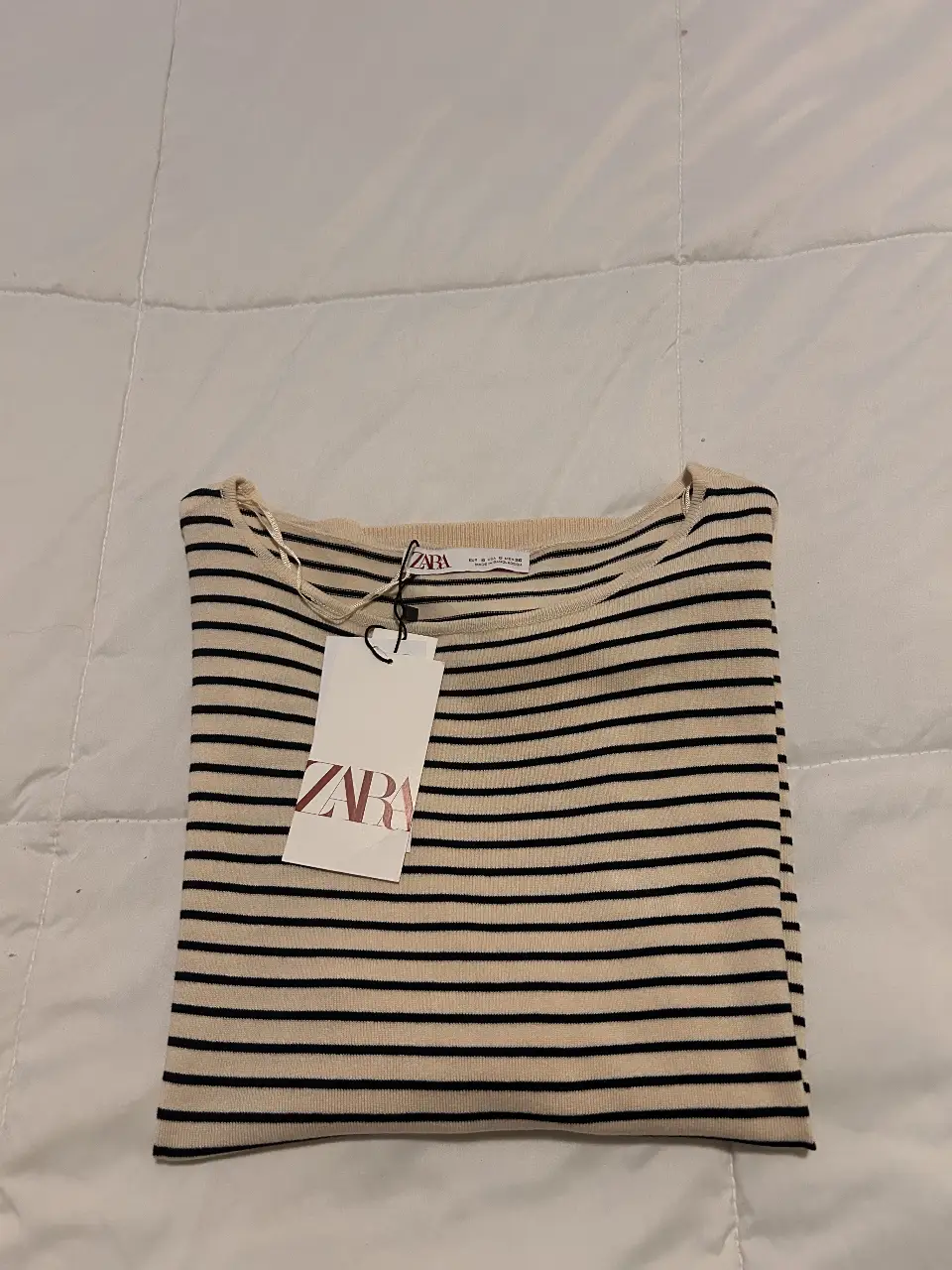 Sweater a rayas de la marca Zara, ideal para un look casual y cómodo. Confeccionado en un tejido suave y ligero, perfecto para usar en cualquier ocasión. Diseño clásico con cuello en V y mangas largas.