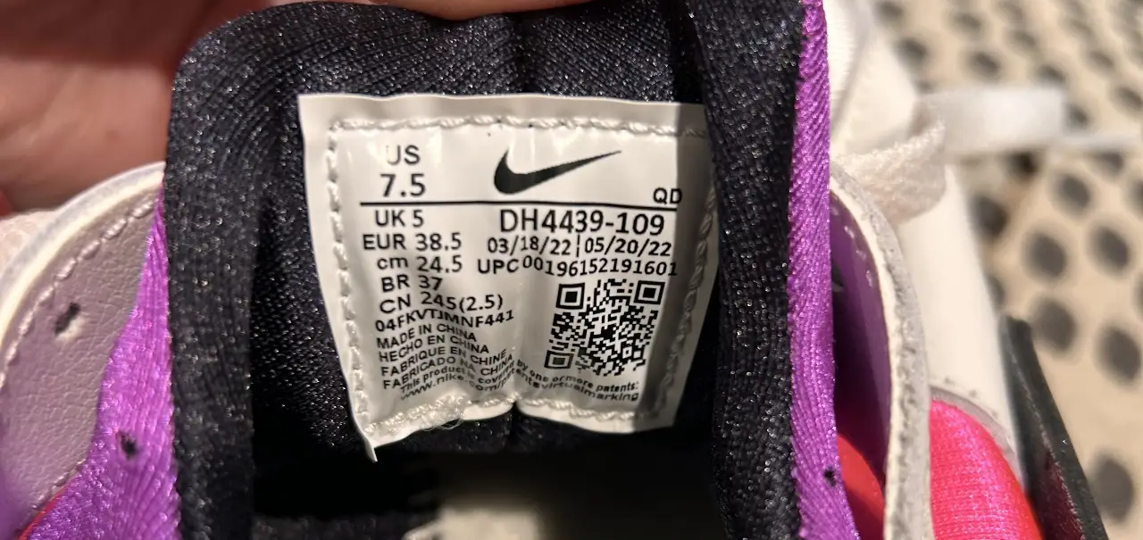 Zapatillas Nike Air Huarache para mujer, con diseño en blanco, rosa y detalles en negro y violeta. Ideales para un look deportivo y moderno.