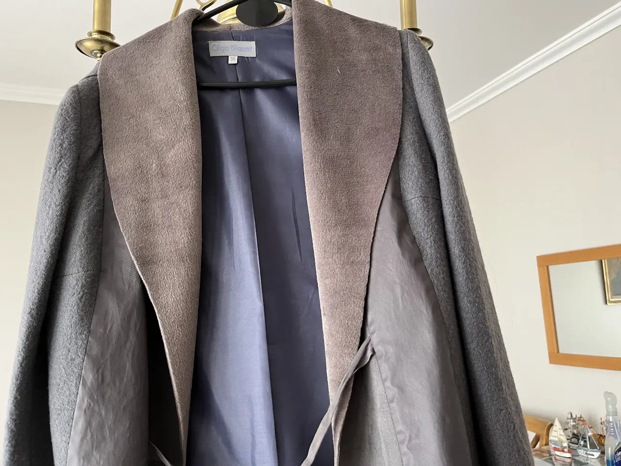 Sobretodo de mujer en tonos grises y marrón, con un diseño elegante y moderno. Ideal para el invierno, este tapado ofrece abrigo y estilo. Confeccionado con materiales de alta calidad, presenta un corte sofisticado y detalles cuidados.