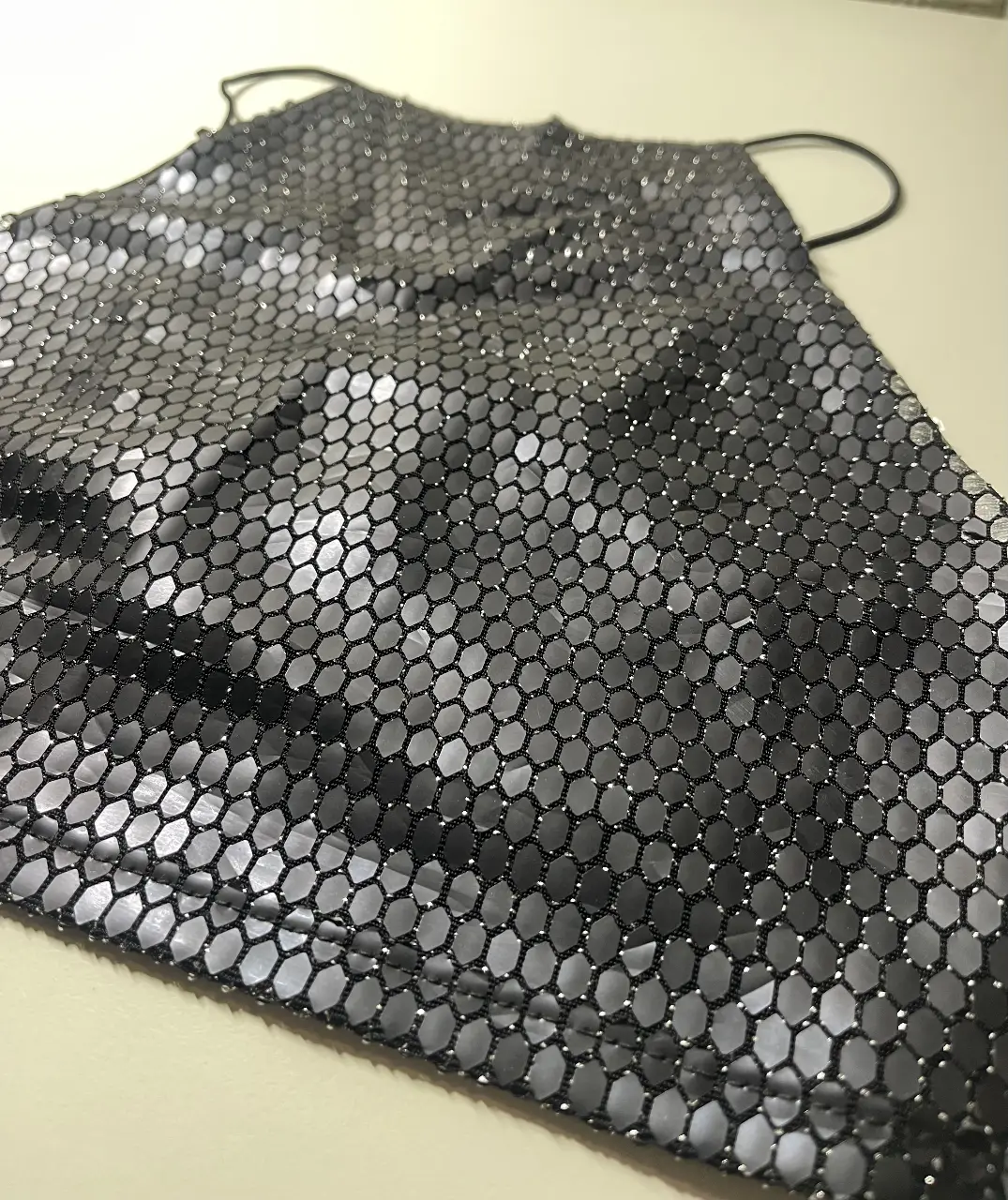 Top negro con diseño de malla hexagonal brillante. Ideal para fiestas y eventos especiales. Un básico moderno y audaz para tu guardarropa.