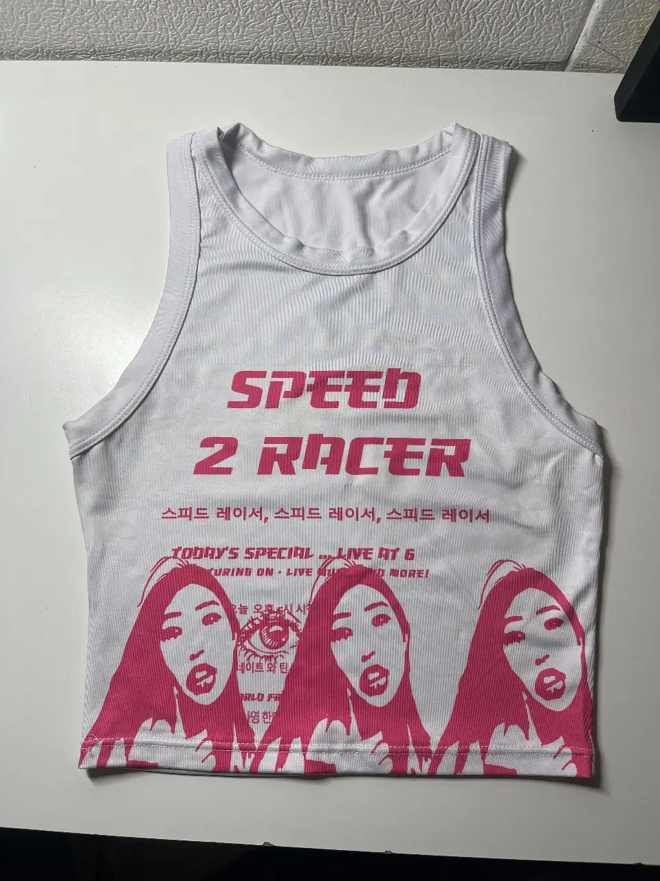 Musculosa crop top blanca con estampado rosa de "Speed 2 Racer". Ideal para un look Y2K y deportivo.