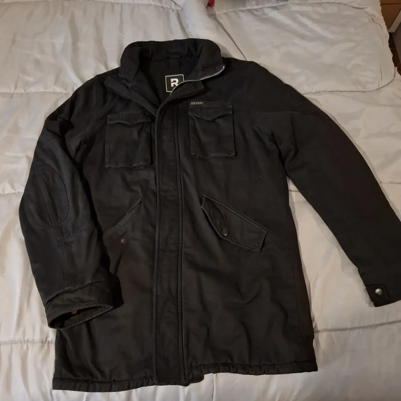 Campera negra de hombre, con forro interior y capucha desmontable. Posee múltiples bolsillos y cierre frontal. Ideal para el invierno, es super abrigada.En excelente estado