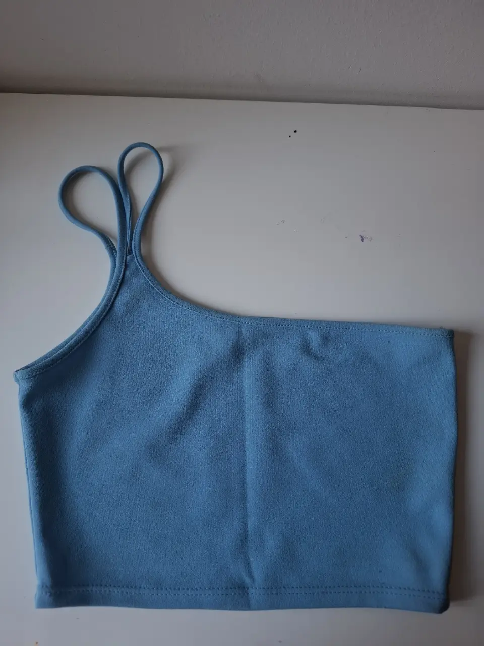 Top celeste asimétrico de un solo hombro, ideal para un look moderno y fresco. Perfecto para combinar con jeans o faldas.