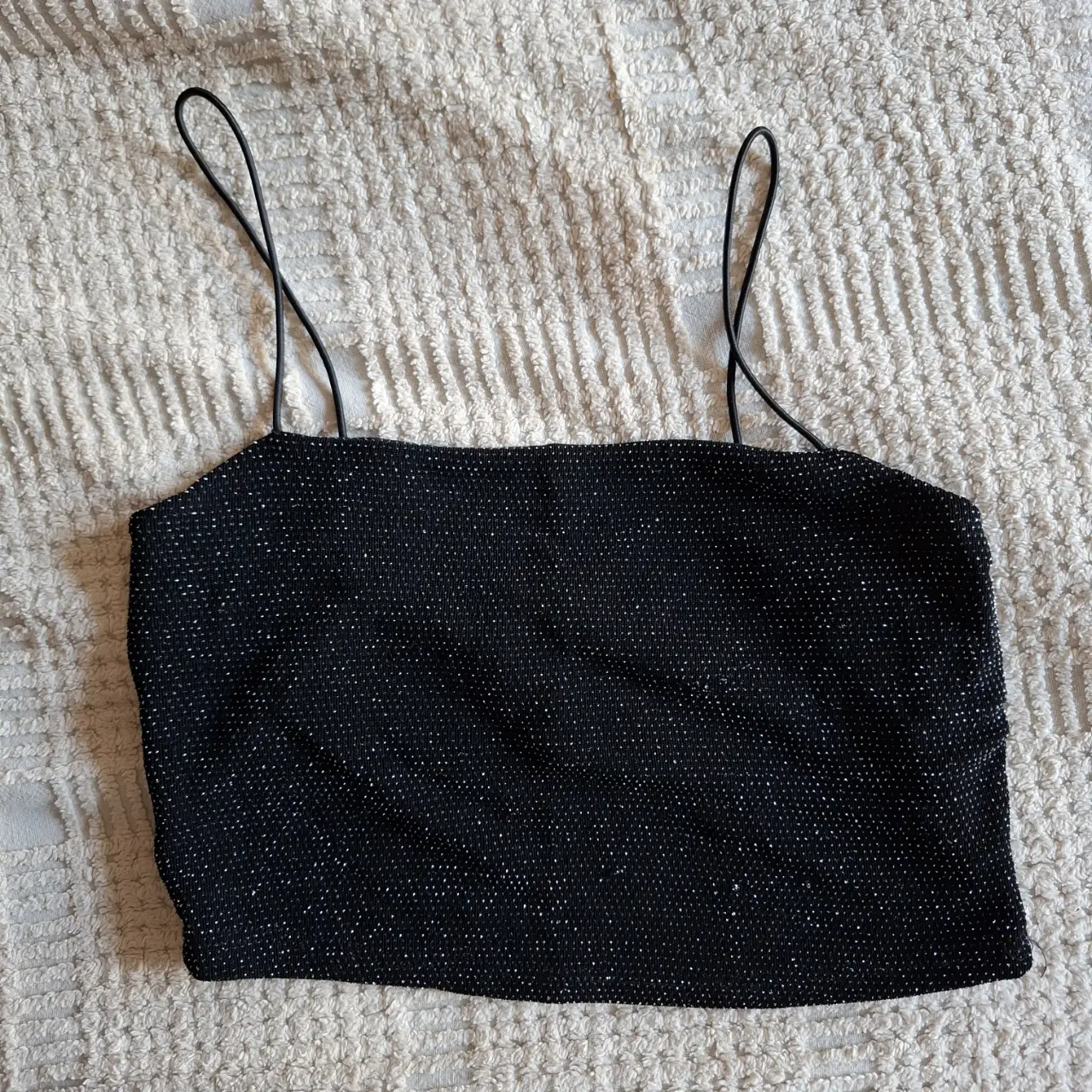 Top negro con brillos, ideal para fiestas y eventos especiales. Diseño elegante y moderno.