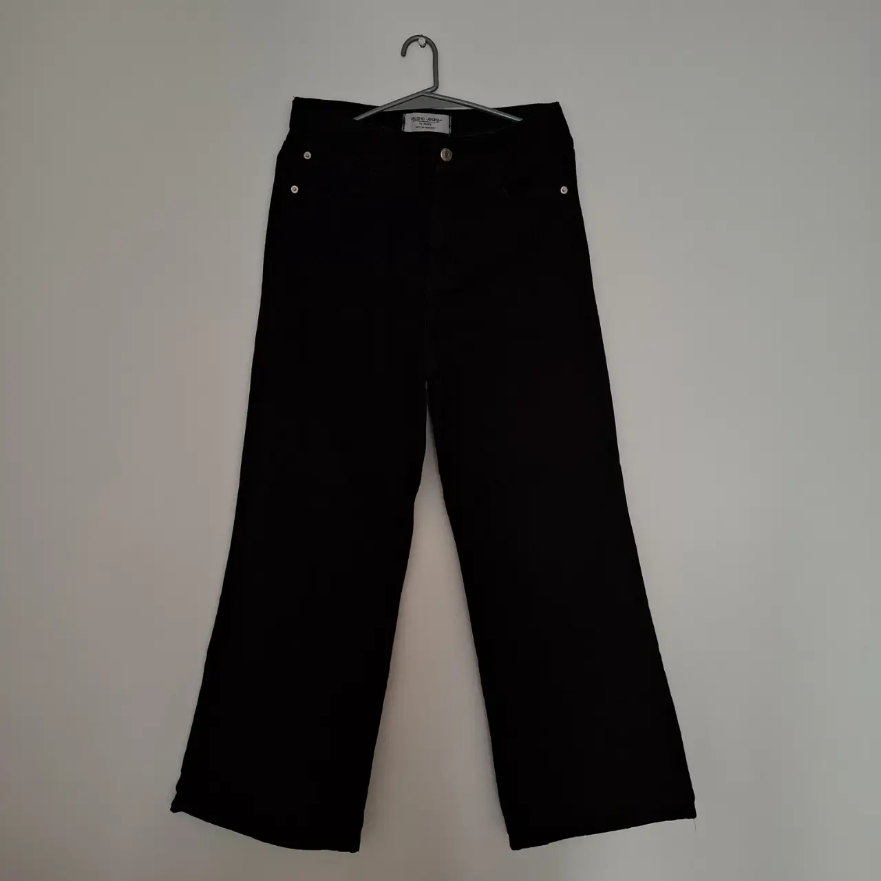 Pantalón negro de corte recto, tiro alto y estilo wide leg. Ideal para un look casual y moderno.