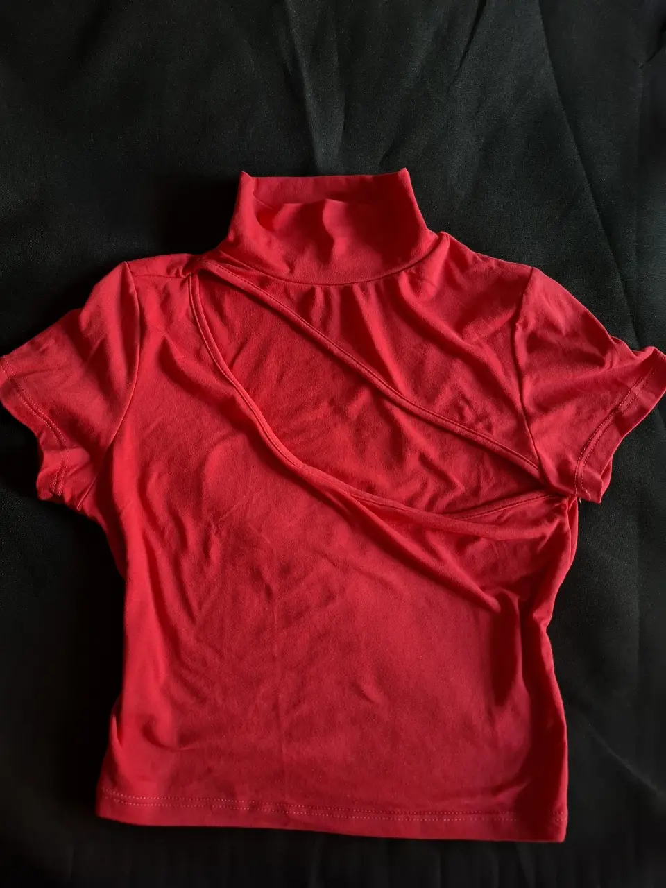 Top rojo con cuello alto y detalle cut-out. Ideal para un look moderno y audaz.