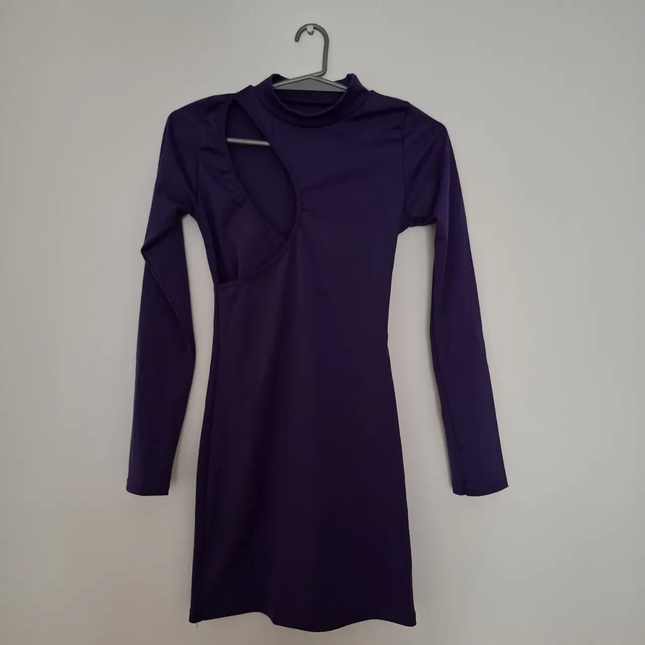 Vestido mini violeta con manga larga y abertura en el pecho. Ideal para una fiesta o salida.
