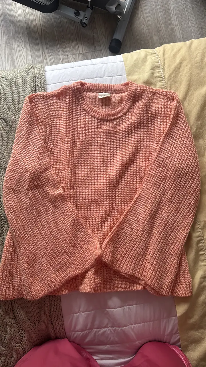 Sweater de punto grueso en color rosa coral, con mangas amplias y corte holgado. Ideal para un look casual y cómodo.