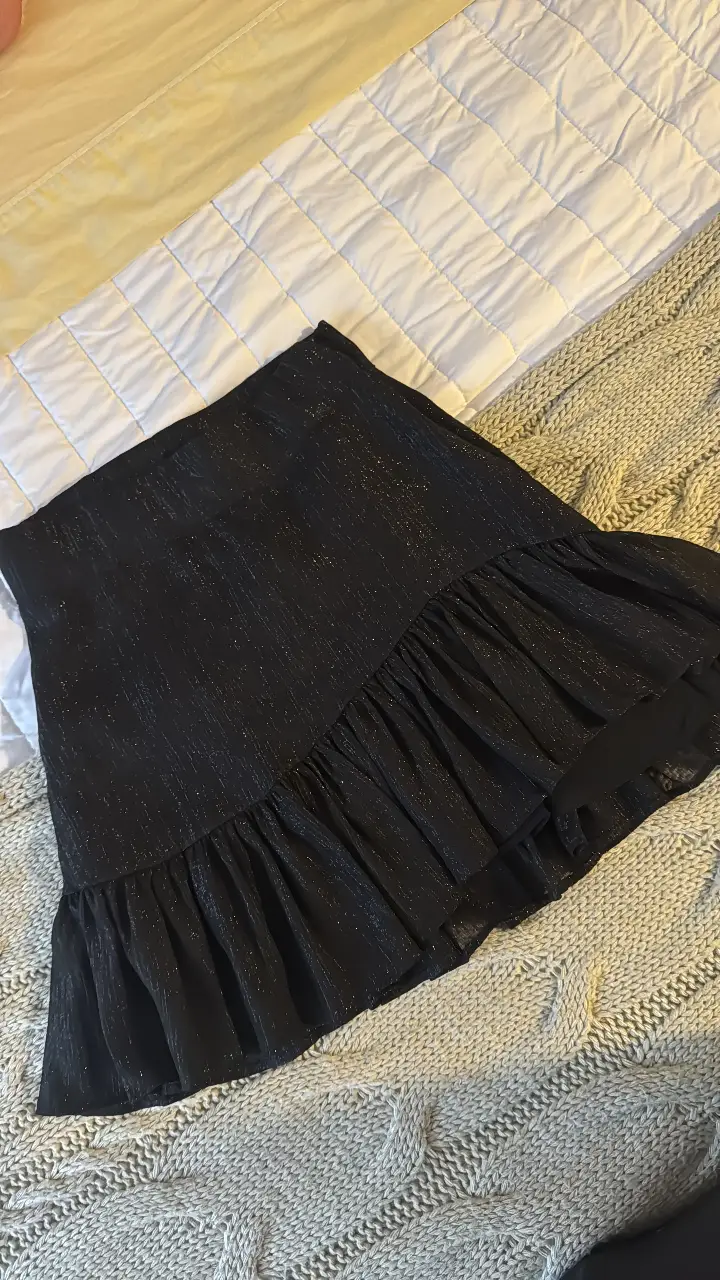 Pollera larga negra con detalles brillantes y volados en el borde. Ideal para eventos especiales o para darle un toque elegante a tu look diario.
