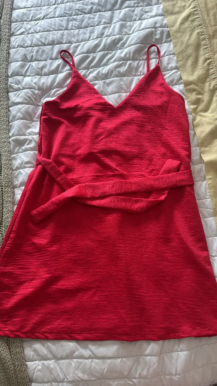 Vestido mini rojo con tirantes finos y cinturón a juego. Ideal para una salida o evento especial.