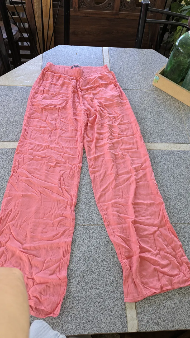 Pantalón largo de color rosa con cintura elastizada y bolsillos laterales.