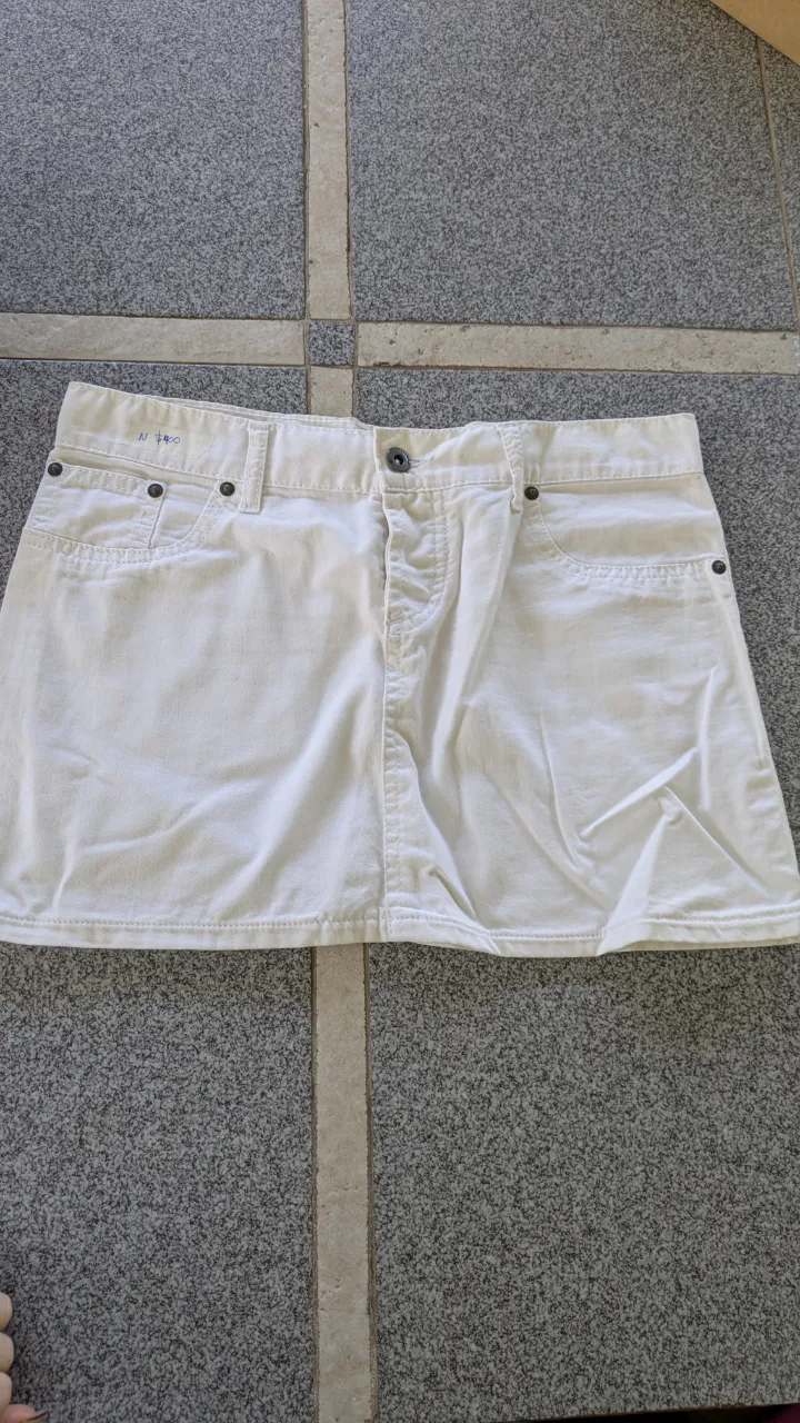 Pollera de jean blanca con detalles de costura y bolsillos.