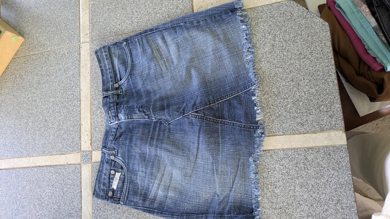 Pollera de jean azul con detalles desgastados y terminación desflecada. Posee bolsillos delanteros y traseros. 