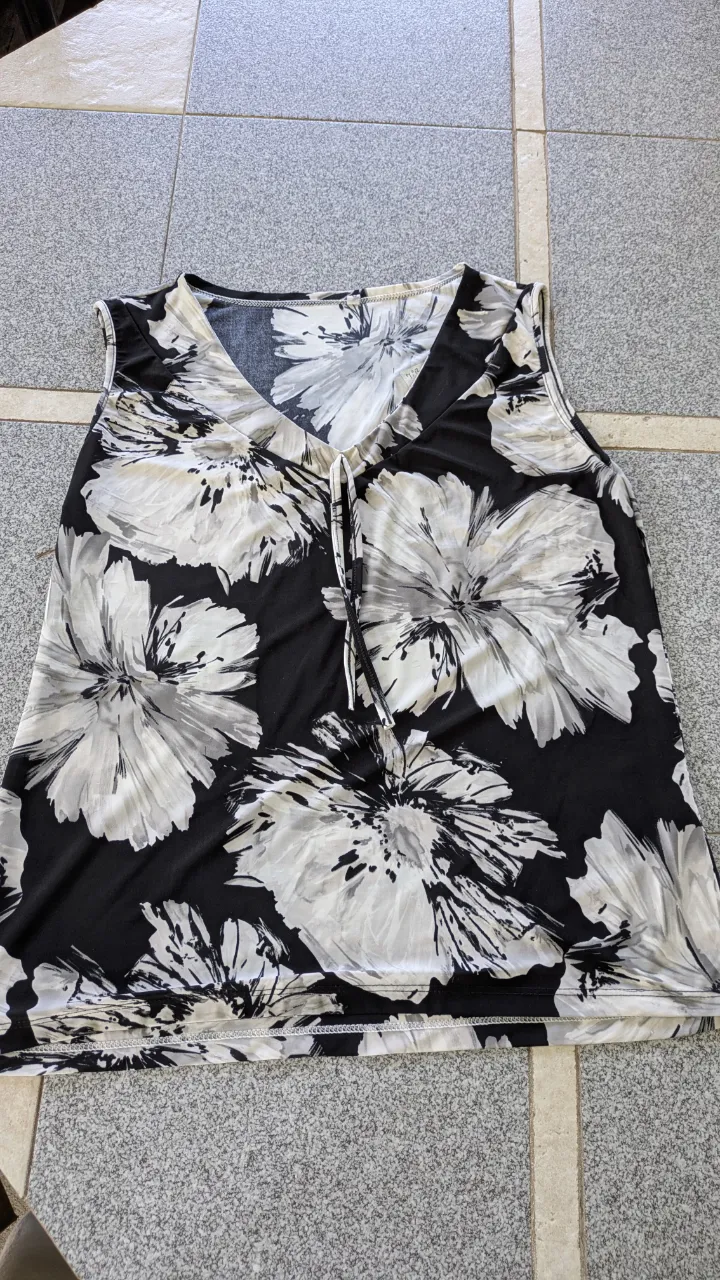 Musculosa estampada con flores en blanco y negro. Posee un lazo en el escote en V. XL