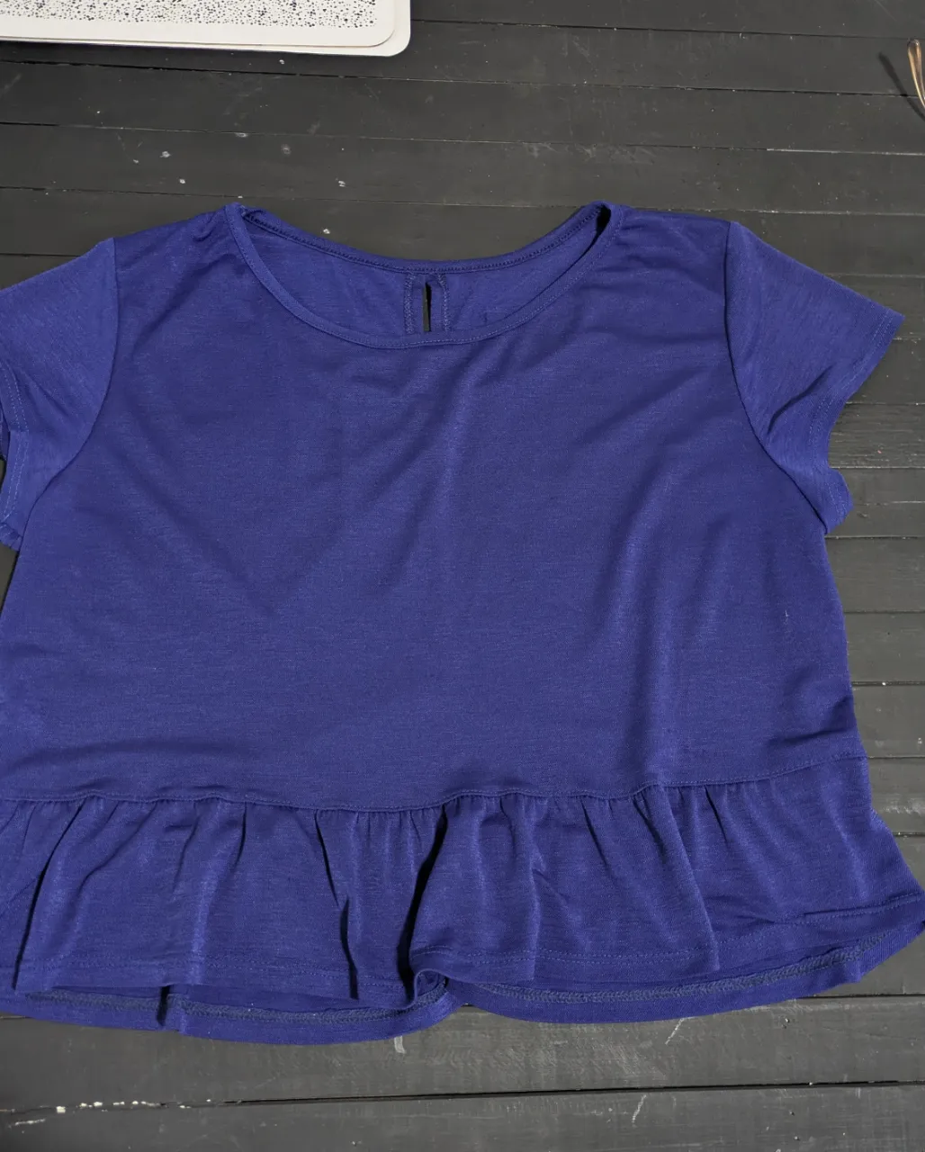 Remera azul con volado en la parte inferior y un detalle de corte en la espalda.