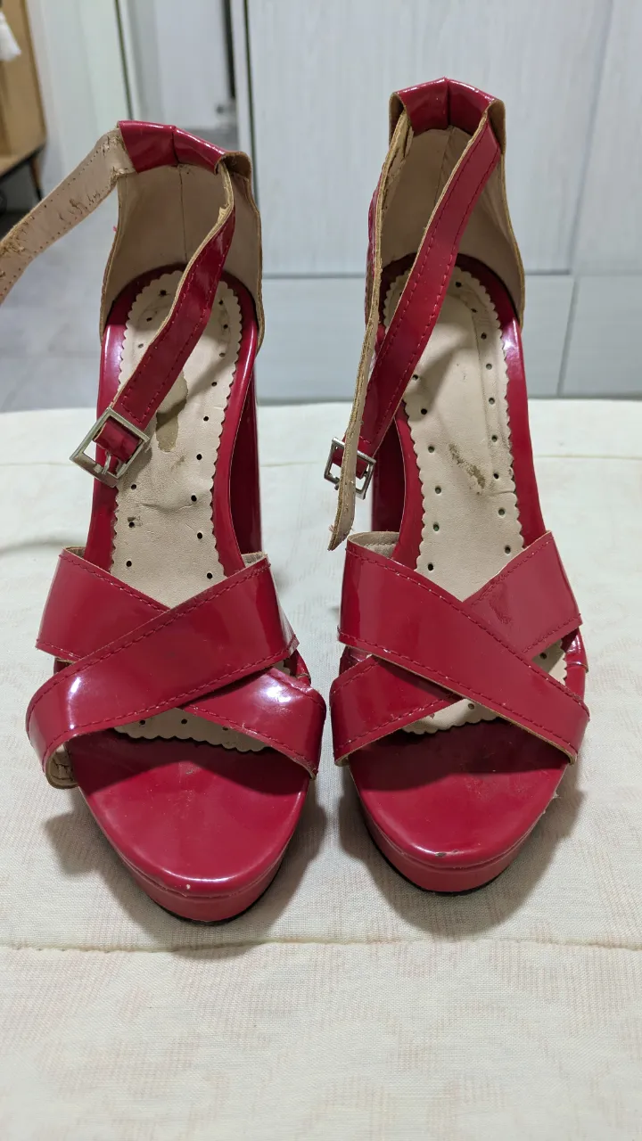 Sandalias de taco alto rojas, con diseño cruzado en la parte delantera y pulsera en el tobillo. Ideales para fiestas y eventos.