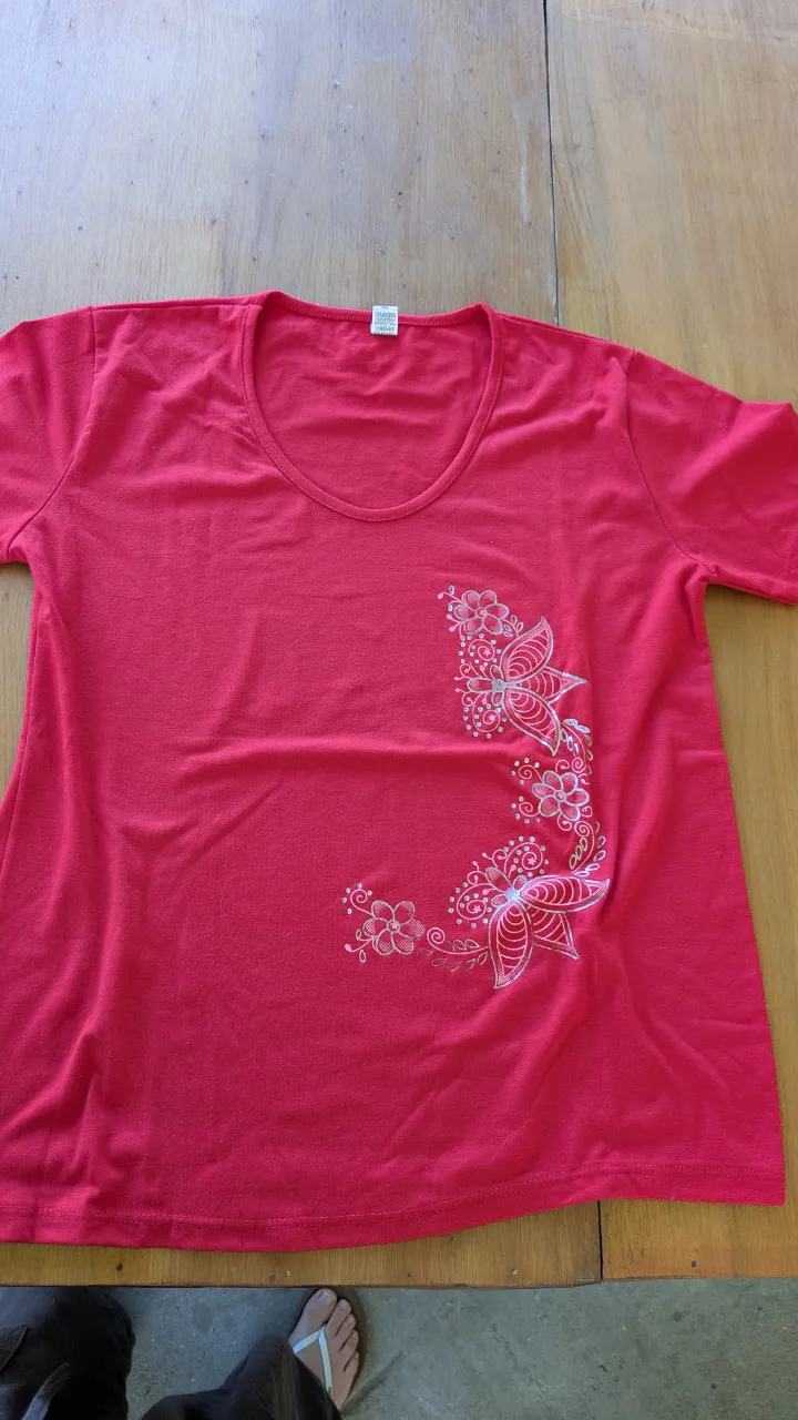Remera roja con estampa floral en un lateral. Ideal para un look casual y fresco.