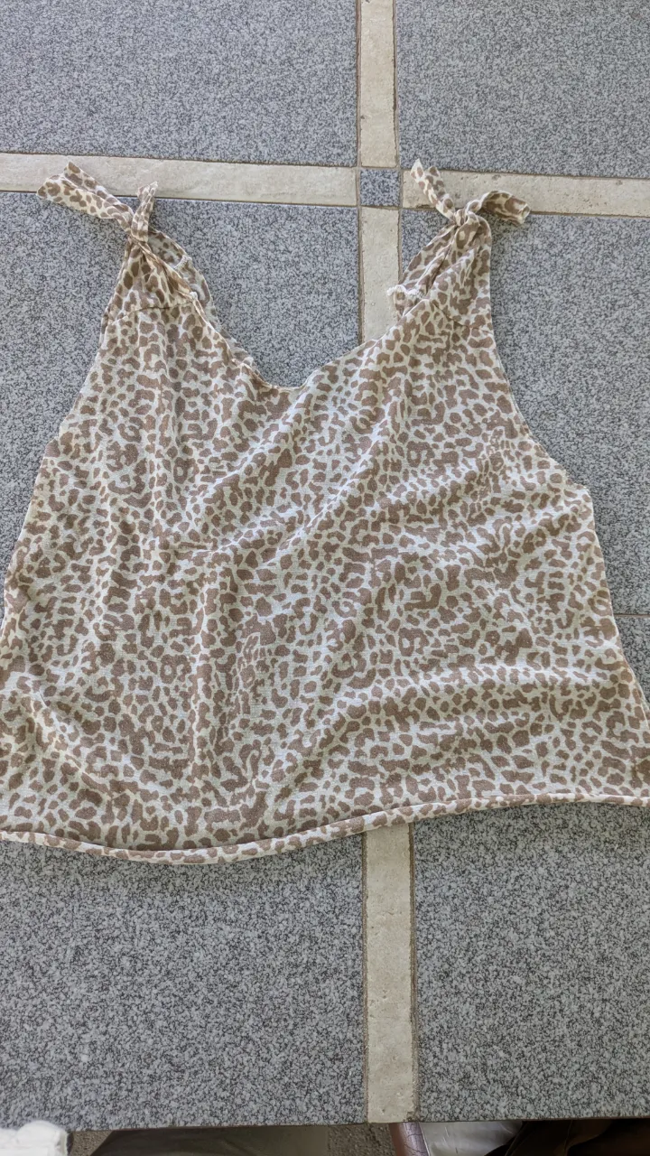 Musculosa con estampa animal print en tonos beige y blanco. Breteles finos con nudo en los hombros.