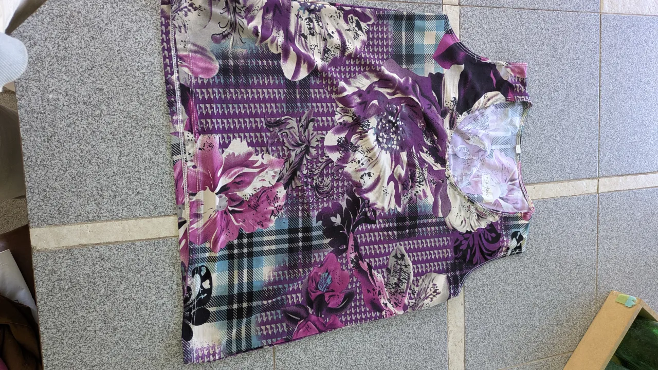 Remera con estampa floral y escocesa en tonos violetas, rosas y negros.