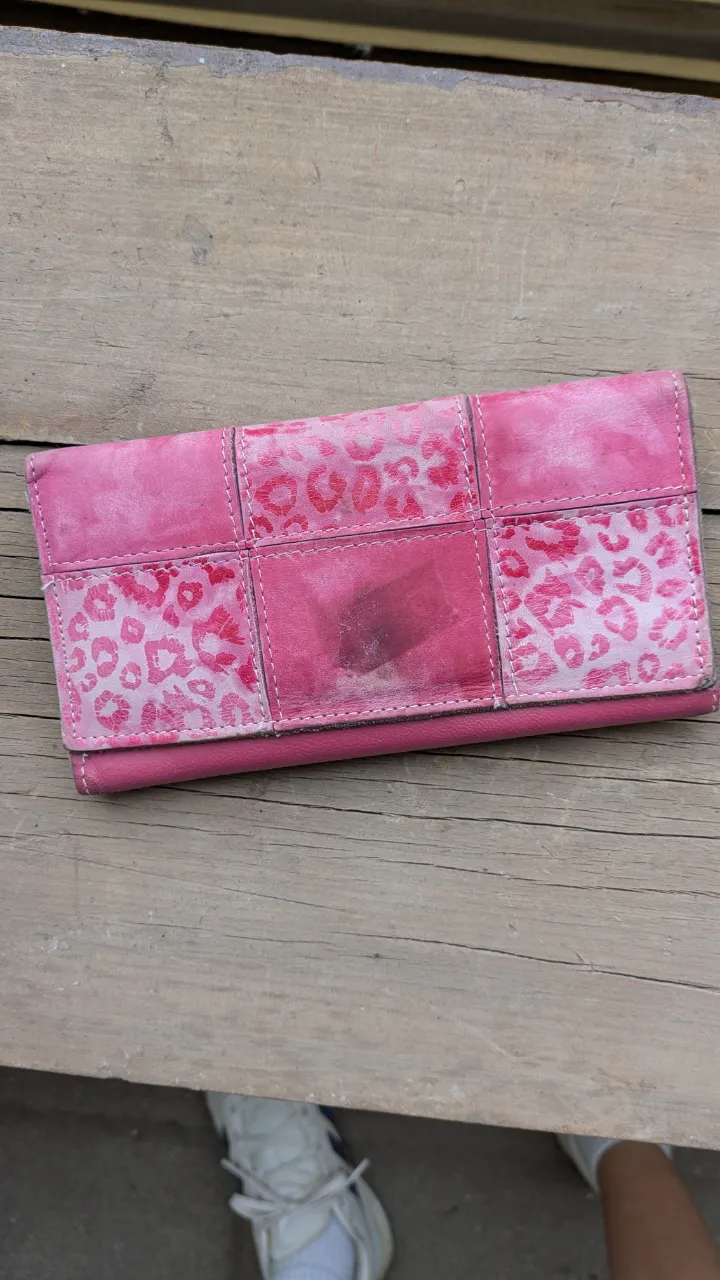 Billetera fucsia con detalles de leopardo en la tapa. Posee compartimentos internos y cierre.