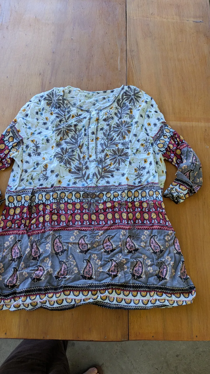 Blusa boho con estampa floral y paisleys. Posee mangas largas y detalles bordados en el frente. Ideal para un look relajado y con estilo.