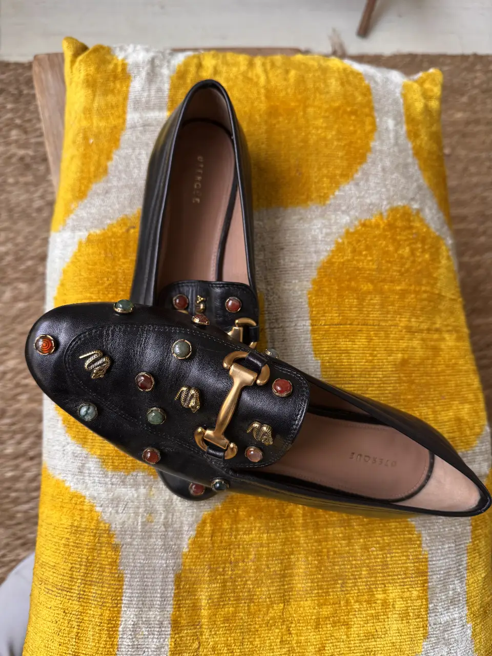 Elegantes mocasines de cuero negro con detalles de piedras y apliques dorados. Perfectos para un look sofisticado y cómodo.
