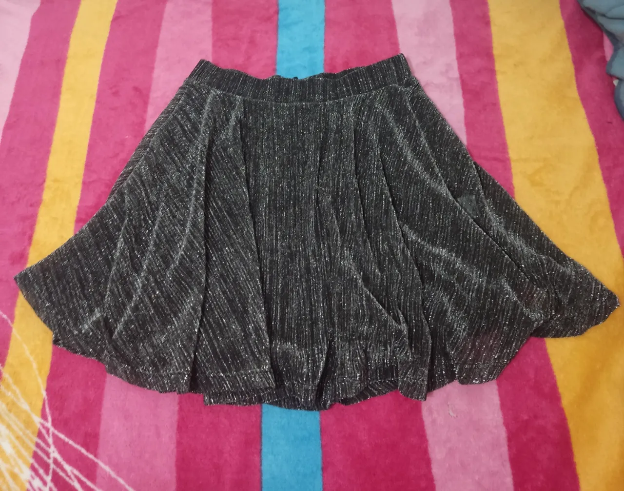 Pollera con diseño plisado y brillos. Ideal para fiestas y eventos especiales.