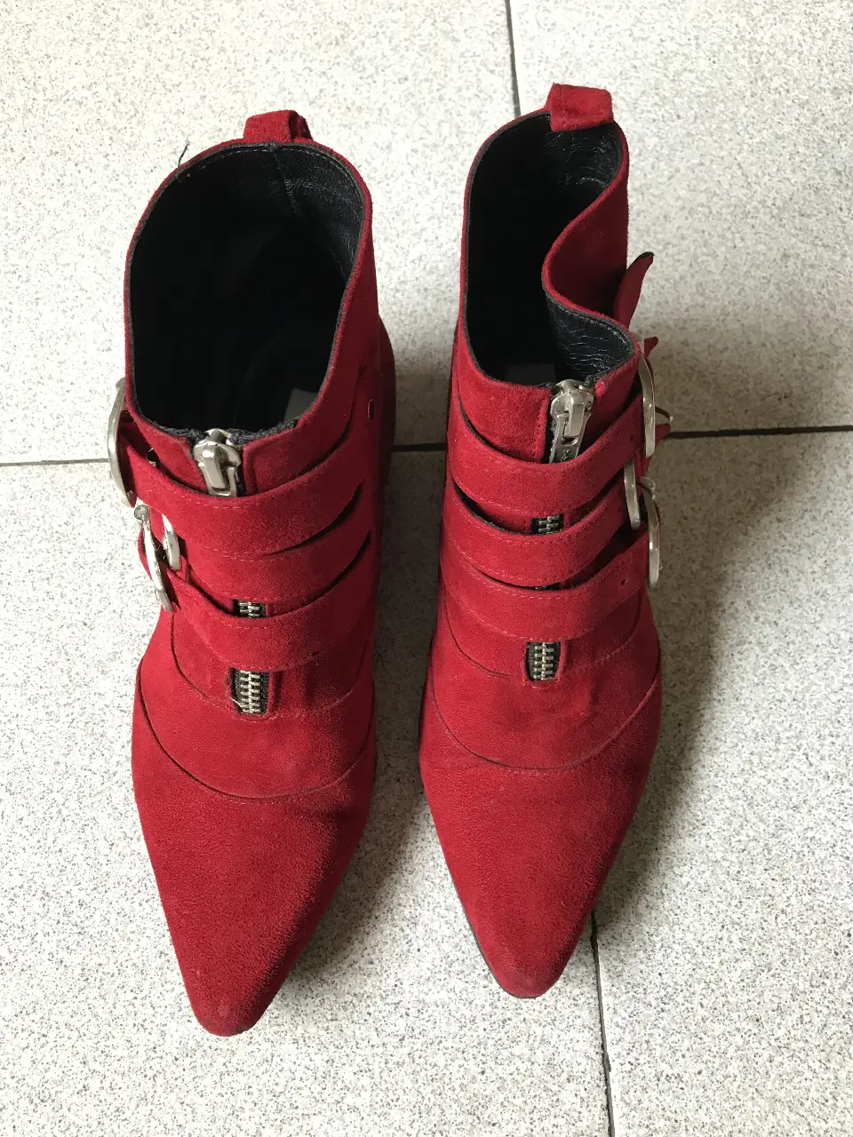 Botines rojos de gamuza con detalles de hebillas y cierres. Ideales para un look moderno y audaz.