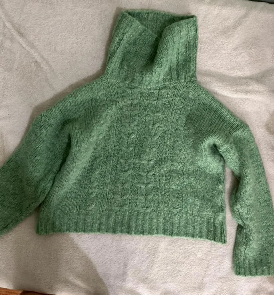 Hermoso sweater tejido color verde menta, con cuello alto y detalles de ochos en el frente. Un básico súper canchero para el día a día.